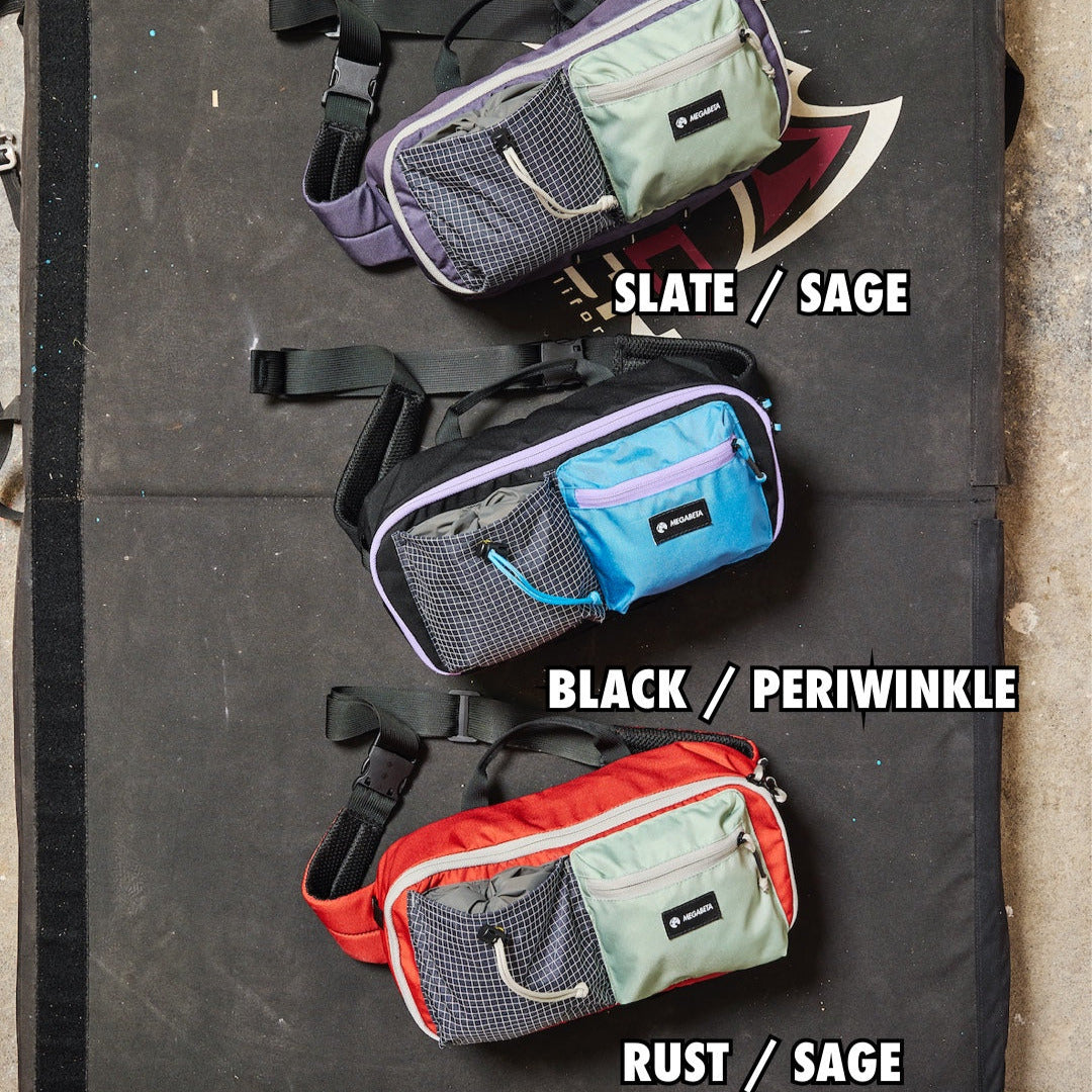 Three sling bags in rust, slate, and black colors, placed on a textured surface. Each bag has a main compartment and additional external pockets, with the words 'RUST', 'Slate', 'Black', 'Periwinkle', 'Rustic', and 'Sage' indicating the colors and materials of the bags.